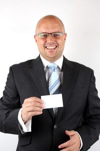 Smiling Businessman Holding a blank businesscard