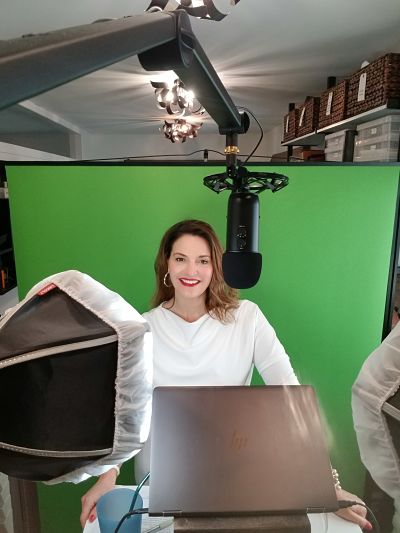 Virtual event auctioneer Sherry Truhlar in front of green screen at a virtual auction event